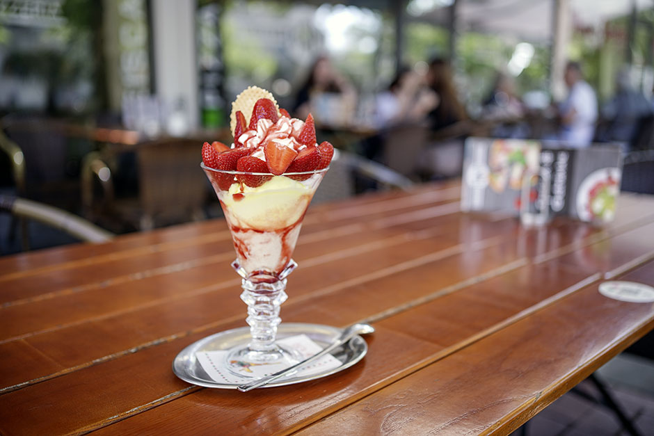 Eisbecher mit frischen Erdbeeren auf der Terrasse des Roni