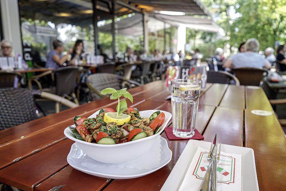 Frischer, schön angerichteter Salat mit Putenbruststreifen auf der Terrasse des Roni