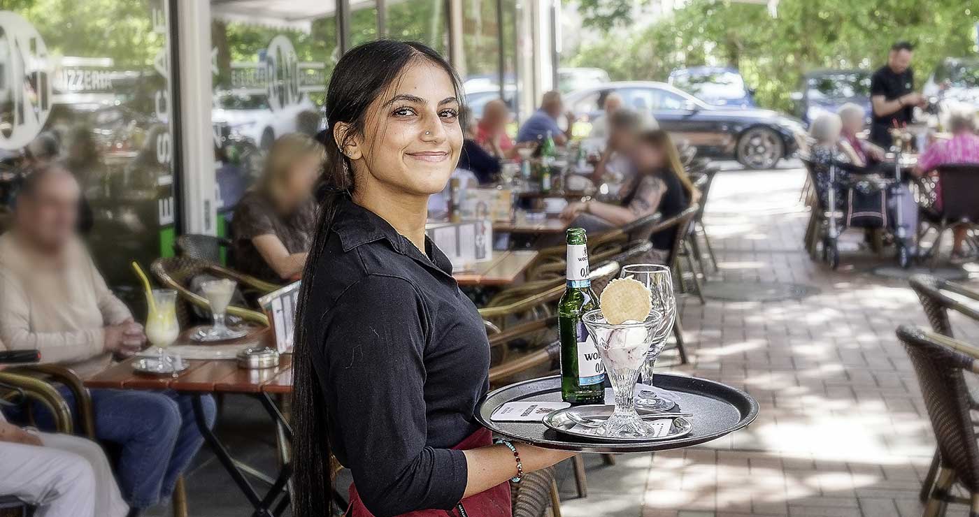 Freundliche Servicekraft auf der gut besuchten Terrasse des Roni in Braunschweig